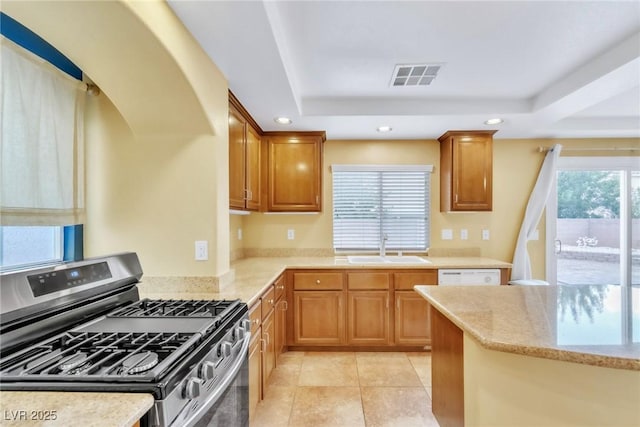 6558 Musette Ave, Las Vegas, NV 89139 - kitchen with stainless steel range with gas cooktop, a tray ceiling, a sink, recessed lighting, and light stone countertops