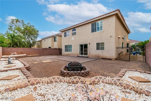 6558 Musette Ave, Las Vegas, NV 89139 - rear view of property featuring an outdoor fire pit, a fenced backyard, stucco siding, a gate, and a patio area