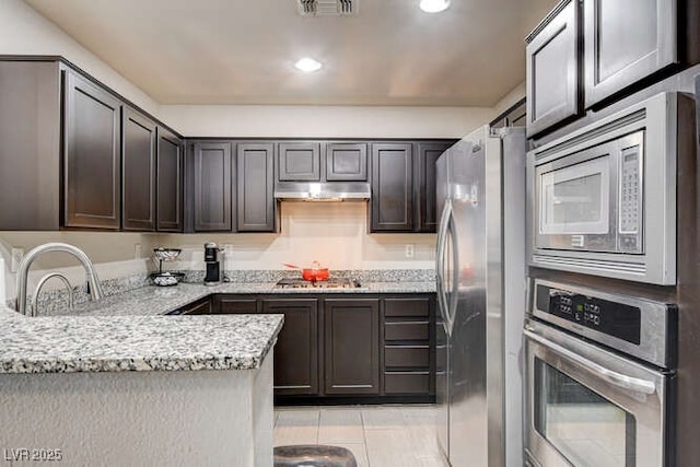 83 E Agate Ave Unit 207, Las Vegas, NV 89123 - kitchen with appliances with stainless steel finishes, under cabinet range hood, light stone countertops, recessed lighting, and a peninsula