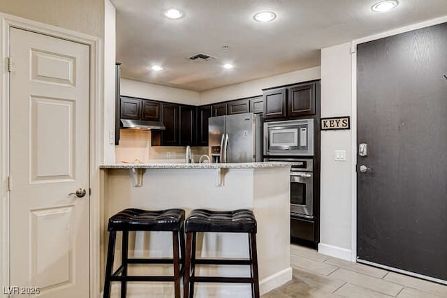 83 E Agate Ave Unit 207, Las Vegas, NV 89123 - kitchen with appliances with stainless steel finishes, a kitchen breakfast bar, under cabinet range hood, recessed lighting, and a peninsula