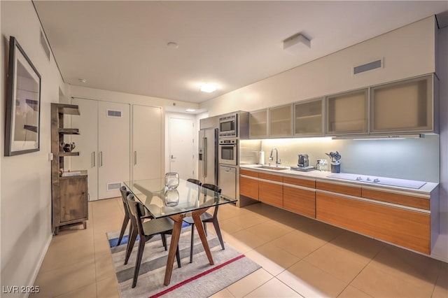 3726 Las Vegas Blvd Unit 3105, Las Vegas, NV 89158 - kitchen featuring stainless steel appliances, a sink, light countertops, glass insert cabinets, and light tile patterned floors
