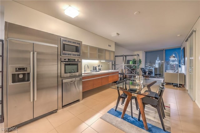 3726 Las Vegas Blvd Unit 3105, Las Vegas, NV 89158 - kitchen with built in appliances, light tile patterned flooring, light countertops, a sink, and glass insert cabinets