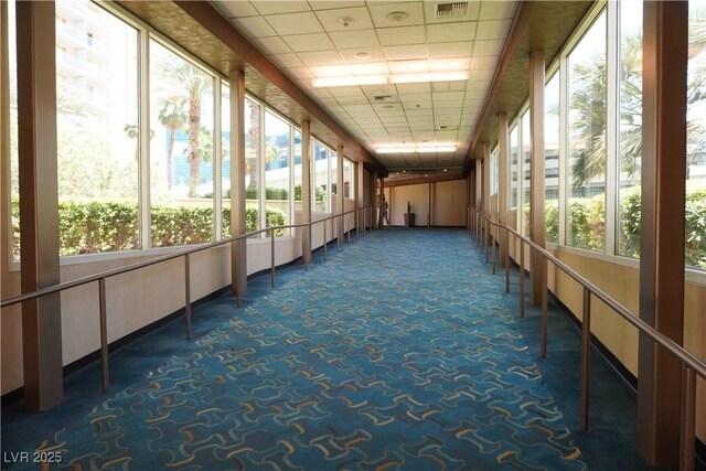 145 E Harmon Ave Unit 27619, Las Vegas, NV 89109 - unfurnished sunroom featuring carpet, a drop ceiling, and plenty of natural light