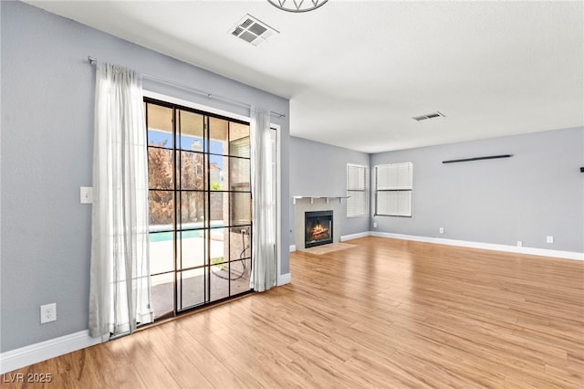 2062 Club Crest Way, Henderson, NV 89014 - unfurnished living room featuring light wood-style floors, baseboards, and a fireplace with flush hearth