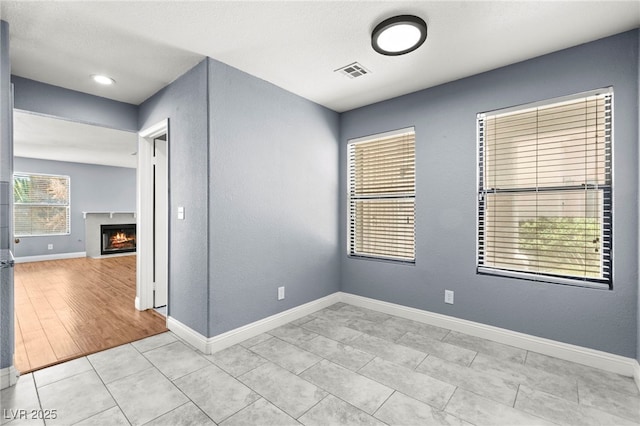 2062 Club Crest Way, Henderson, NV 89014 - empty room with a lit fireplace, baseboards, and light tile patterned floors