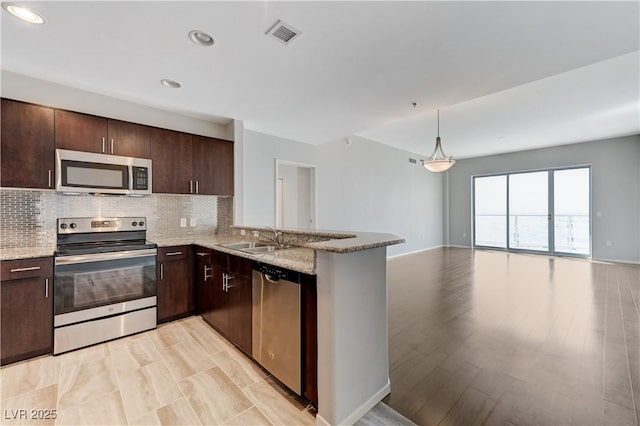 8255 S Las Vegas Blvd Unit 1816, Las Vegas, NV 89123 - kitchen with stainless steel appliances, a sink, open floor plan, dark brown cabinetry, and tasteful backsplash