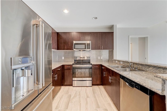 8255 S Las Vegas Blvd Unit 1816, Las Vegas, NV 89123 - kitchen featuring appliances with stainless steel finishes, a sink, light stone counters, tasteful backsplash, and dark brown cabinetry