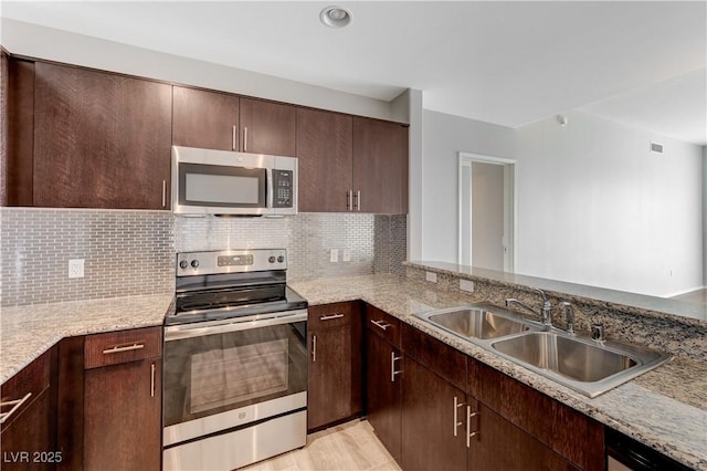 8255 S Las Vegas Blvd Unit 1816, Las Vegas, NV 89123 - kitchen with stainless steel appliances, a sink, backsplash, dark brown cabinetry, and light stone counters