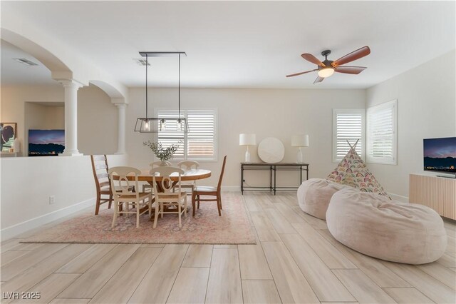 8504 Mystic Night Ave, Las Vegas, NV 89143 - dining room featuring decorative columns, arched walkways, wood finished floors, and healthy amount of natural light