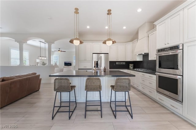 8504 Mystic Night Ave, Las Vegas, NV 89143 - kitchen featuring stainless steel appliances, open floor plan, dark countertops, a kitchen breakfast bar, and recessed lighting