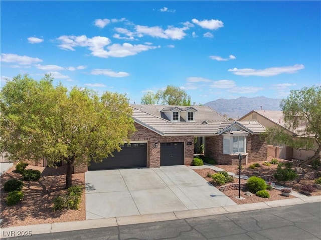 8504 Mystic Night Ave, Las Vegas, NV 89143 - view of front of property with an attached garage, a tiled roof, driveway, a mountain view, and brick siding