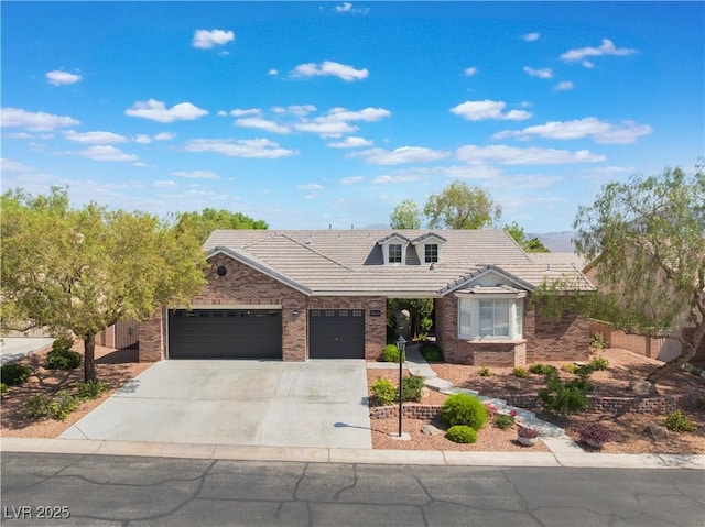 8504 Mystic Night Ave, Las Vegas, NV 89143 - view of front of house with an attached garage, brick siding, driveway, and a tiled roof