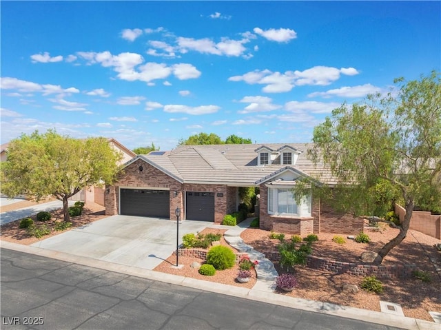 8504 Mystic Night Ave, Las Vegas, NV 89143 - view of front of property featuring an attached garage, concrete driveway, brick siding, and a tiled roof