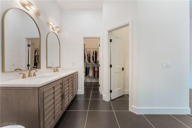 8504 Mystic Night Ave, Las Vegas, NV 89143 - bathroom featuring double vanity, a walk in closet, tile patterned flooring, and baseboards