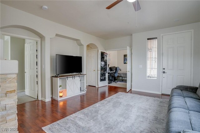 10605 Moon Flower Arbor Pl, Las Vegas, NV 89144 - living room with arched walkways, a ceiling fan, wood finished floors, and baseboards