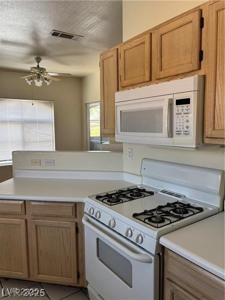 9000 Las Vegas Blvd Unit 2189, Las Vegas, NV 89123 - kitchen featuring white appliances, ceiling fan, light countertops, a peninsula, and a textured ceiling