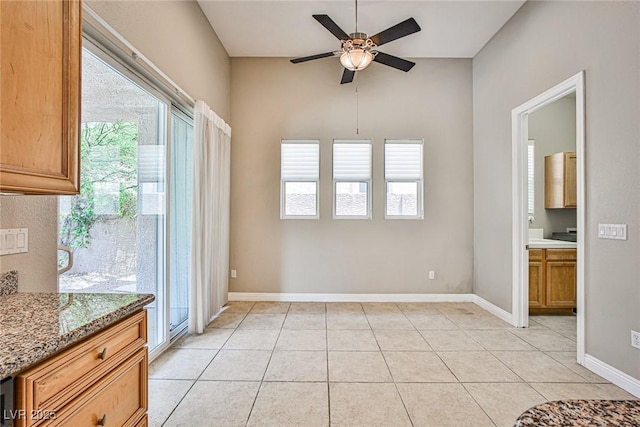 213 Villa Borghese St, Las Vegas, NV 89138 - unfurnished dining area featuring a ceiling fan, healthy amount of natural light, light tile patterned flooring, lofted ceiling, and baseboards