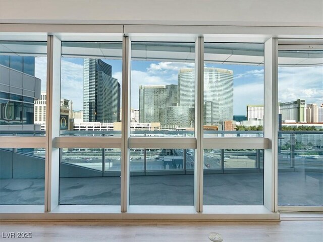4471 Dean Martin Dr Unit 1109, Las Vegas, NV 89103 - doorway to outside featuring plenty of natural light, a skyline view, expansive windows, and wood finished floors