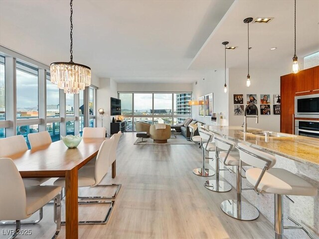 4471 Dean Martin Dr Unit 1109, Las Vegas, NV 89103 - dining space featuring light wood-style flooring and a chandelier