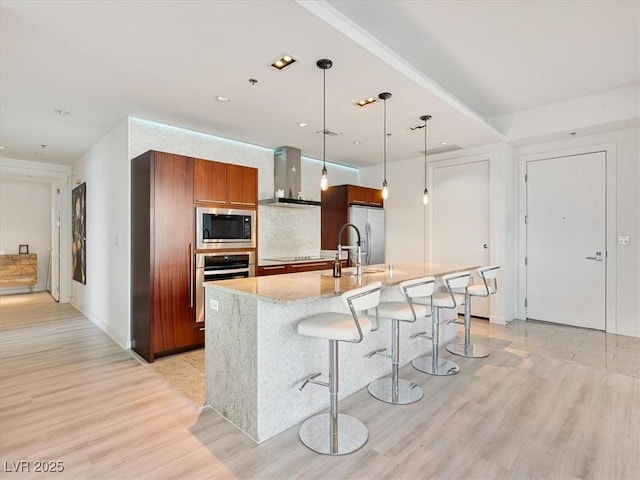 4471 Dean Martin Dr Unit 1109, Las Vegas, NV 89103 - kitchen featuring appliances with stainless steel finishes, wall chimney range hood, light wood finished floors, a sink, and modern cabinets