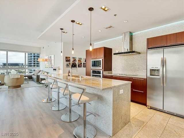 4471 Dean Martin Dr Unit 1109, Las Vegas, NV 89103 - kitchen with appliances with stainless steel finishes, wall chimney range hood, a sink, a kitchen bar, and open floor plan