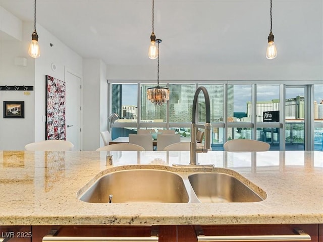 4471 Dean Martin Dr Unit 1109, Las Vegas, NV 89103 - kitchen featuring a sink, light stone counters, and decorative light fixtures