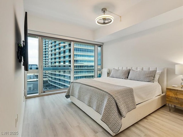 4471 Dean Martin Dr Unit 1109, Las Vegas, NV 89103 - bedroom with multiple windows, wood finished floors, and access to exterior