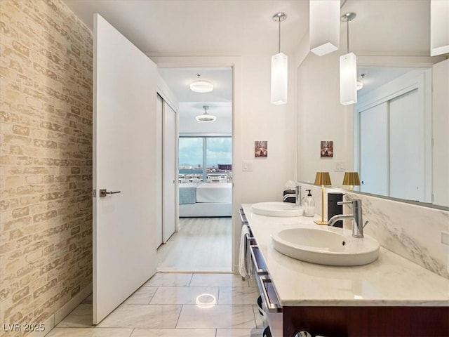4471 Dean Martin Dr Unit 1109, Las Vegas, NV 89103 - ensuite bathroom featuring double vanity, brick wall, and marble look tiles