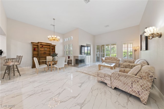 1912 Summer Pine Ct Unit 102, Las Vegas, NV 89134 - living area with a chandelier, plenty of natural light, marble finish floors, and a towering ceiling