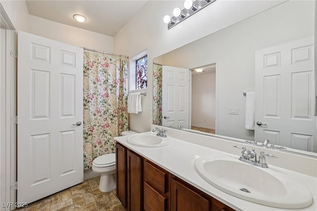 8224 Fowler Falls Ct, North Las Vegas, NV 89085 - bathroom featuring toilet, double vanity, stone finish flooring, and a shower with curtain