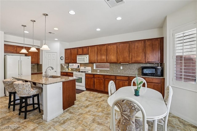 8224 Fowler Falls Ct, North Las Vegas, NV 89085 - kitchen with white appliances, a sink, tasteful backsplash, light stone finish floors, and recessed lighting