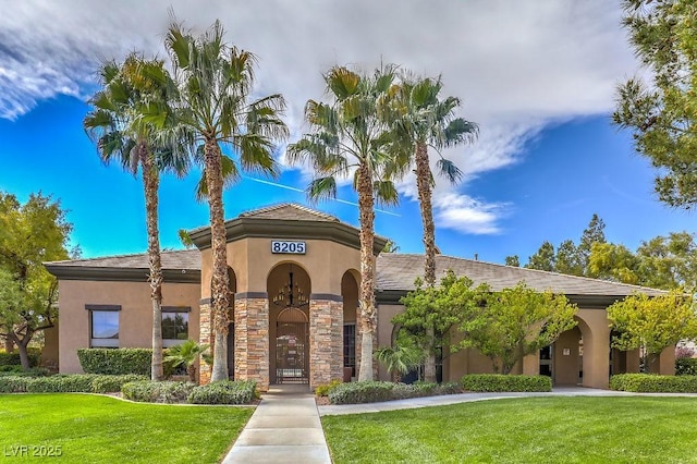 8224 Fowler Falls Ct, North Las Vegas, NV 89085 - view of front of house with stucco siding, a front yard, and stone siding