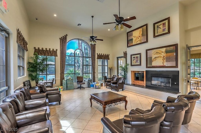 8224 Fowler Falls Ct, North Las Vegas, NV 89085 - living area with a ceiling fan, a high end fireplace, tile patterned flooring, recessed lighting, and a towering ceiling