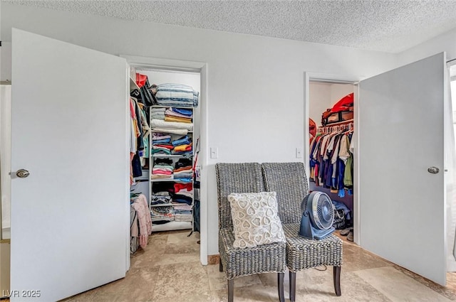 872 N Linn Ln, Las Vegas, NV 89110 - bedroom featuring a walk in closet, a closet, a textured ceiling, and stone finish floors