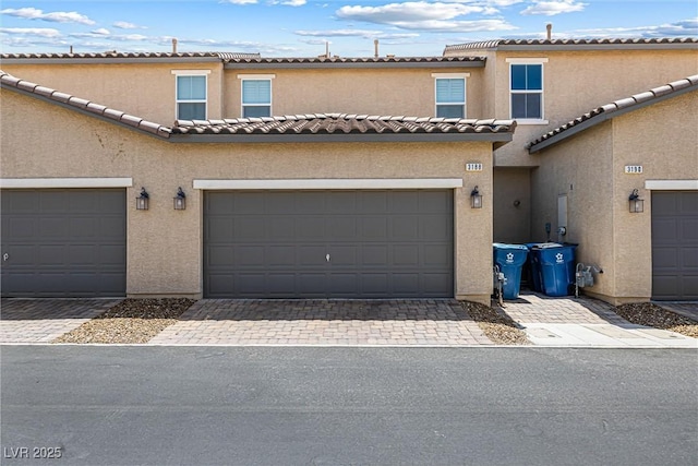 3188 Via Da Vinci, Henderson, NV 89044 - view of property featuring stucco siding, a garage, driveway, and a tiled roof