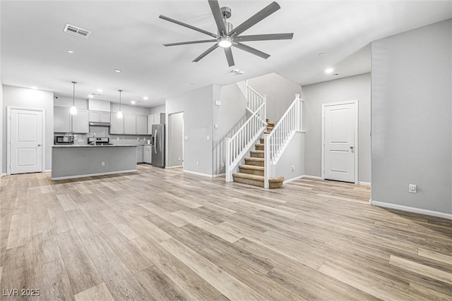 3188 Via Da Vinci, Henderson, NV 89044 - unfurnished living room with ceiling fan, stairway, light wood-style floors, recessed lighting, and baseboards