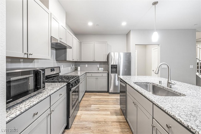 3188 Via Da Vinci, Henderson, NV 89044 - kitchen with appliances with stainless steel finishes, a sink, under cabinet range hood, gray cabinetry, and light wood-type flooring