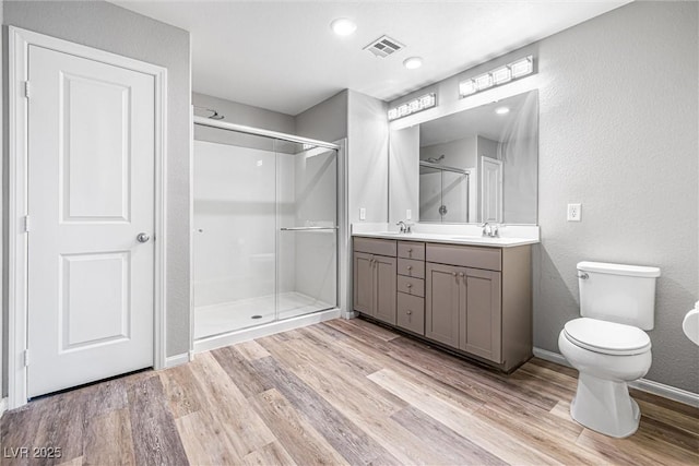 3188 Via Da Vinci, Henderson, NV 89044 - full bathroom with double vanity, wood finished floors, a stall shower, a textured wall, and toilet