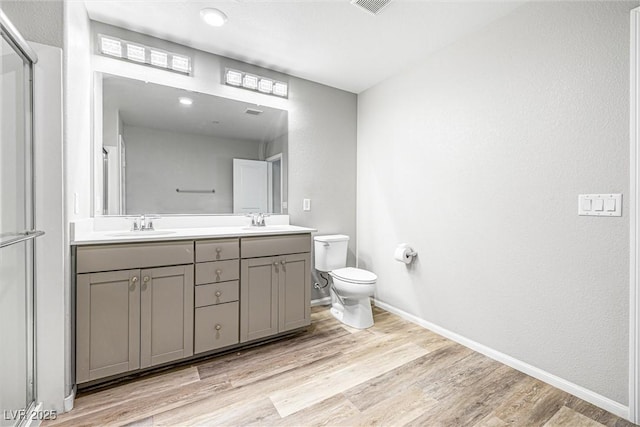3188 Via Da Vinci, Henderson, NV 89044 - full bathroom featuring toilet, double vanity, wood finished floors, and baseboards