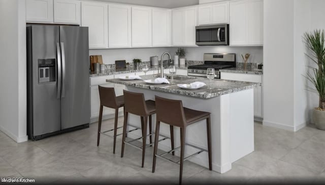 871 Apatite Pl Lot 54, Henderson, NV 89011 - kitchen featuring appliances with stainless steel finishes, light stone counters, white cabinetry, an island with sink, and a kitchen breakfast bar
