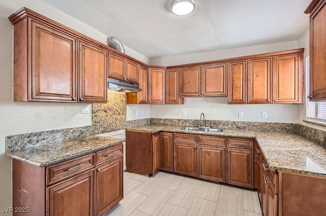 1404 Atlantic St, Las Vegas, NV 89104 - kitchen featuring a sink, under cabinet range hood, brown cabinets, and stone counters