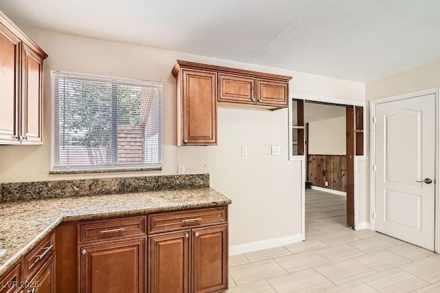 1404 Atlantic St, Las Vegas, NV 89104 - kitchen featuring brown cabinets, baseboards, and light stone countertops