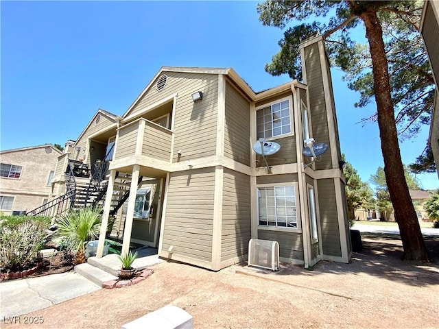 4682 Leeann Ln, Las Vegas, NV 89121 - view of front of house featuring stairs, a chimney, ac unit, and a balcony