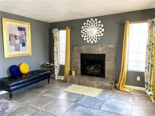 4682 Leeann Ln, Las Vegas, NV 89121 - living room featuring baseboards, a tile fireplace, and stone finish floors
