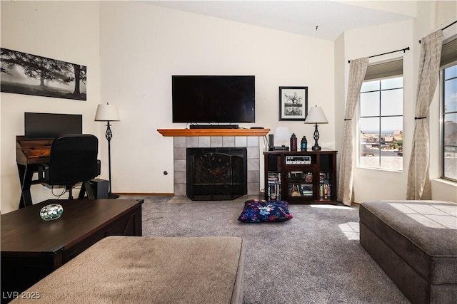 3236 Manzanita Ln, Laughlin, NV 89029 - carpeted living room featuring a tiled fireplace, an office area, lofted ceiling, and baseboards