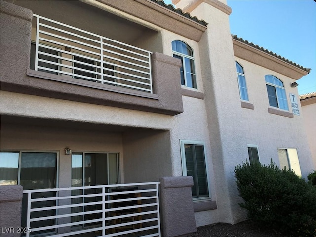 4555 E Sahara Ave Unit 226, Las Vegas, NV 89104 - rear view of house featuring stucco siding, a balcony, and a tile roof