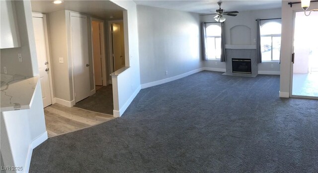4555 E Sahara Ave Unit 226, Las Vegas, NV 89104 - unfurnished living room with light carpet, a fireplace with flush hearth, ceiling fan, and baseboards