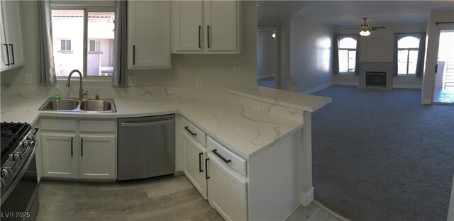 4555 E Sahara Ave Unit 226, Las Vegas, NV 89104 - kitchen with stainless steel dishwasher, a sink, range with gas cooktop, ceiling fan, and open floor plan