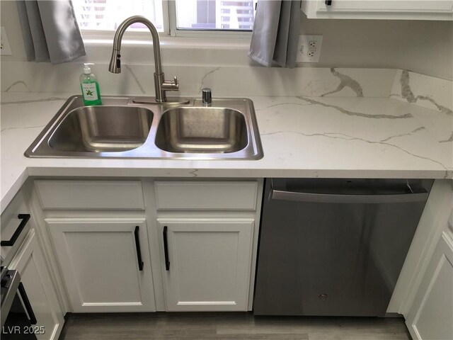 4555 E Sahara Ave Unit 226, Las Vegas, NV 89104 - kitchen view of stainless steel dishwasher, a sink, white cabinets, and light stone countertops
