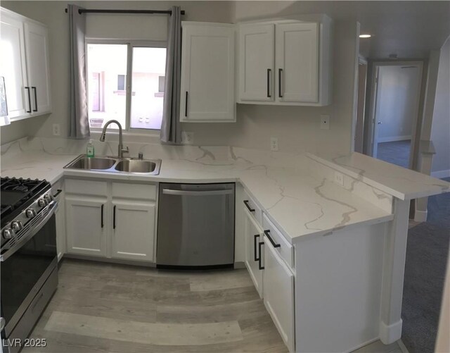 4555 E Sahara Ave Unit 226, Las Vegas, NV 89104 - kitchen featuring stainless steel appliances, a sink, white cabinetry, a peninsula, and light stone countertops